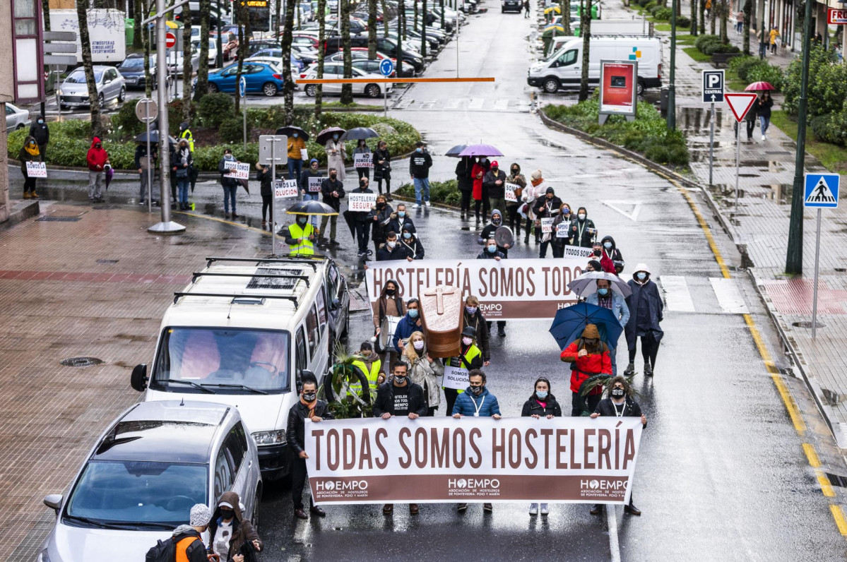 Dos niños se acercan a un grupo de hosteleros antes de que inicien una marcha en defensa del sector de la hostelería, en Pontevedra, Galicia (España), a 7 de diciembre de 2020. Al finalizar esta ma