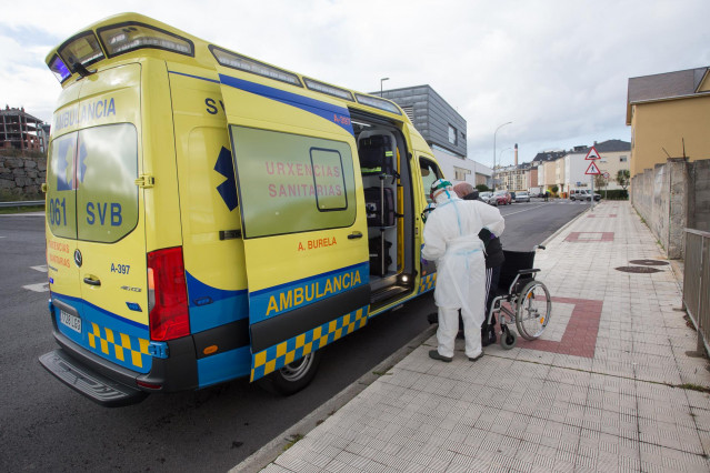 Un trabajador sanitario totalmente protegido ayuda a subir a la ambulancia a un anciano de la residencia de ancianos de San Cibrao donde se ha originado un brote de Covid-19, en San Cibrao, Lugo, Galicia, (España), a 9 de noviembre de 2020. En el centro l