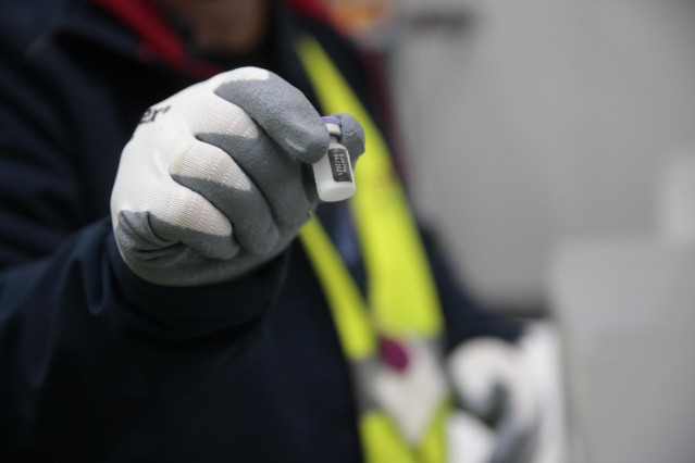 Una persona de los laboratorios que han desarrollado las vacunas, Pfizer y BioNtech muestra una dosis de la vacuna para entregarlas a técnicos de la Agencia Española de Medicamentos y Productos Sanitarios para su certificación y a personal del Ejército qu