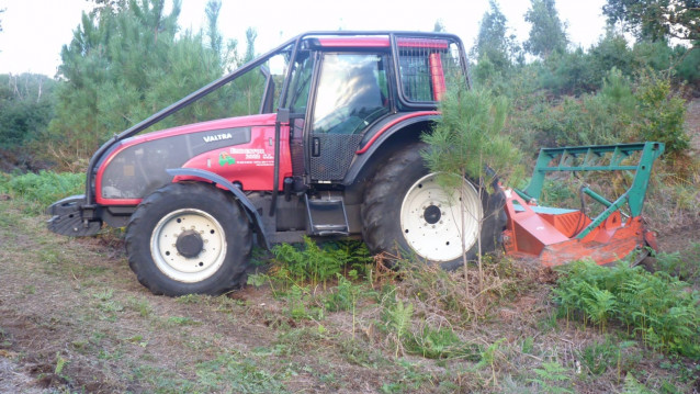 Un tractor desbroza en una finca en Galicia