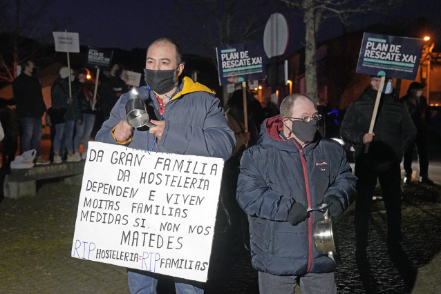 Dos hombres protestan frente a la casa de Feijóo. Convocados por las asociaciones Hostelería Compostela y Bares, Pubs e Discotecas de Compostela, hosteleros de Santiago de Compostela