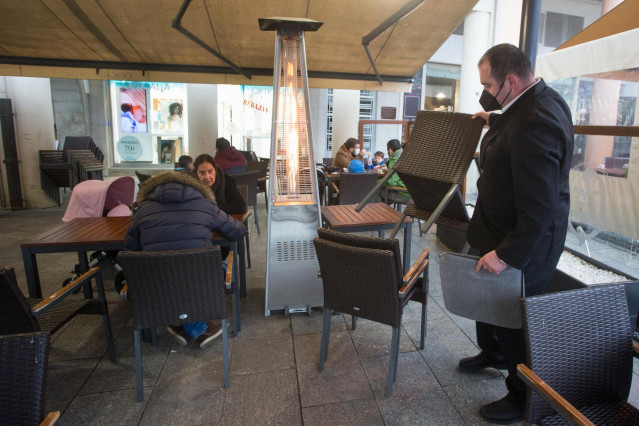 Un camarero recoge las sillas y mesas el primer día del cierre perimetral decretado en Lugo a 15 de enero de 2021