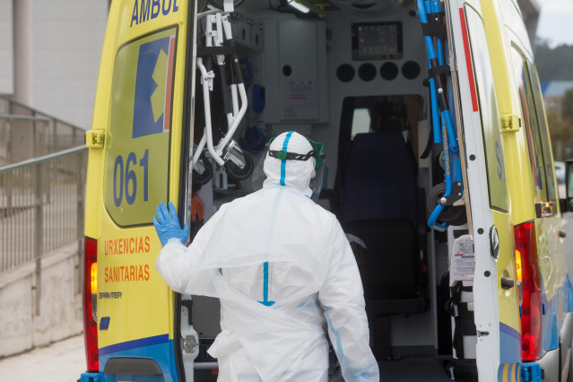 Un trabajador sanitario totalmente protegido cierra la puerta de una ambulancia tras recoger a un anciano de la residencia de ancianos de San Cibrao donde se ha originado un brote de Covid-19, en San Cibrao, Lugo, Galicia, (España), a 9 de noviembre de 20