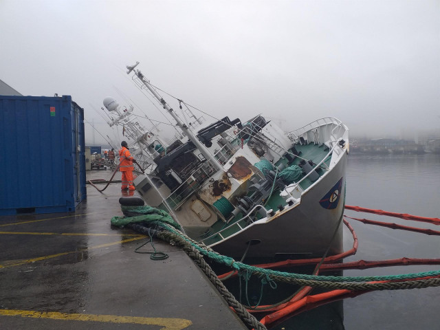 El buque arrastrero 'Baffin Bay', escorado y semihundido en el muelle de reparaciones de Bouzas, tras los daños sufridos por un incendio en diciembre de 2020.