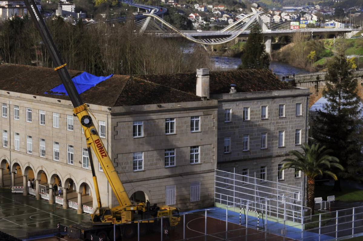 Una grúa interviene en los trabajos de reparación del tejado del colegio de los Salesianos de Ourense, Galicia (España), a 3 de febrero de 2021.