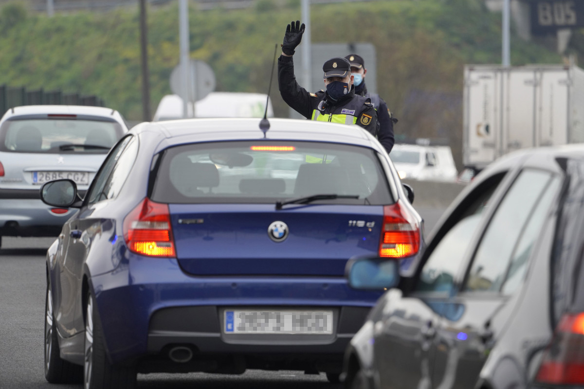 Un agente de la Policía Local da el alto a un coche durante un control de movilidad en la salida de Santiago de Compostela hacia la carretera de Ourense, en el barrio de Castiñeiriño, en Santiago d