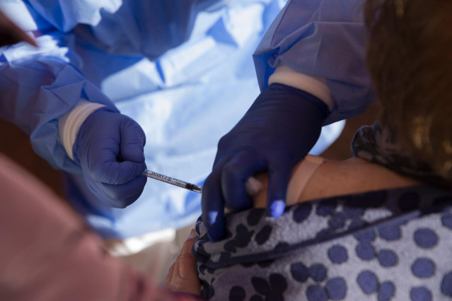 Una mujer mayor de 90 años recibe la vacuna de Pfizer contra la Covid-19, en una carpa habilitada en la explanada del centro de salud del municipio Lora del Río. En Sevilla (Andalucía, España), a 15 de febrero de 2021.