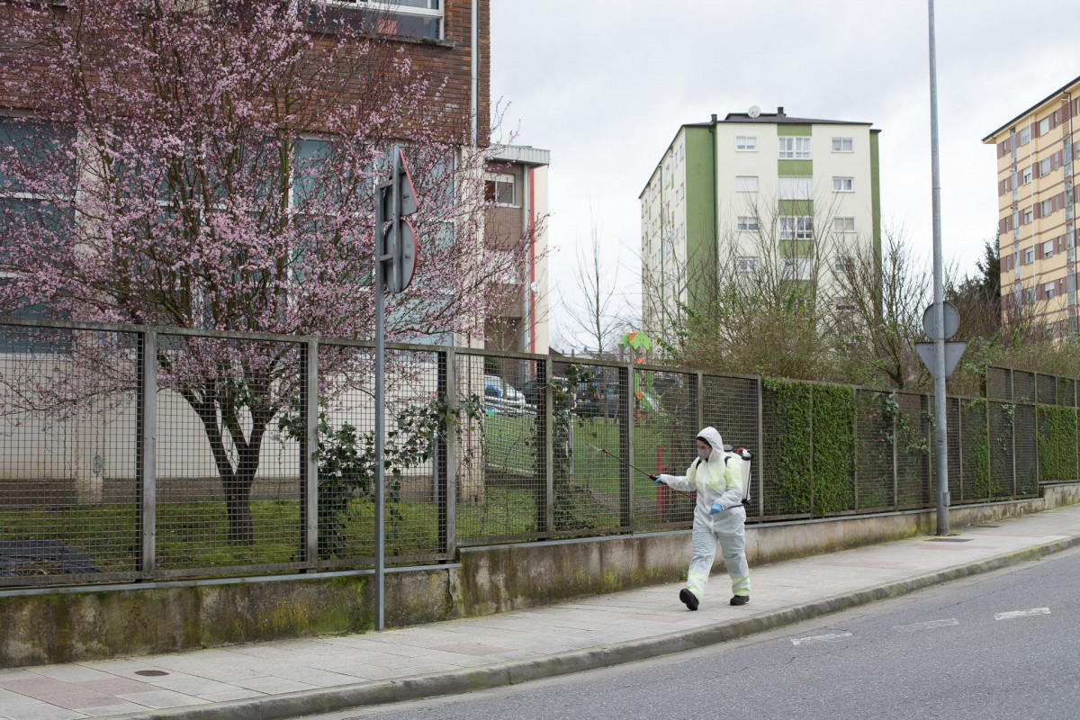 Una persona desinfecta el perímetro que rodea el colegio público CEIP  Paradai, en Lugo, Galicia (España), a 19 de febrero de 2021. Sanidad de Lugo confirmó ayer que ascienden a 60 los positivos d