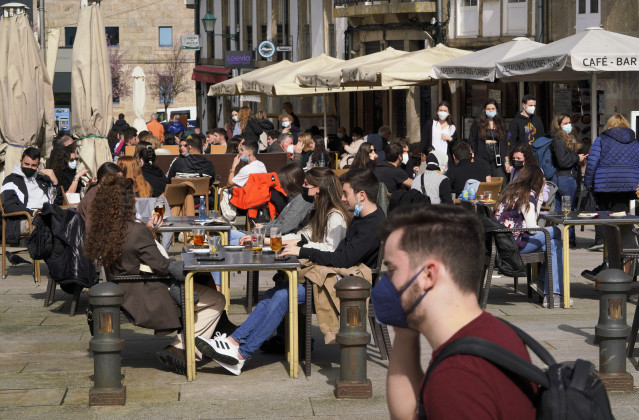 Varias personas en la terraza de un restaurante durante el primer día de la apertura parcial de la hostelería en Santiago de Compostela, A Coruña, Galicia (España), a 26 de febrero de 2021. La Xunta de Galicia reabre desde hoy parcialmente la hostelería y