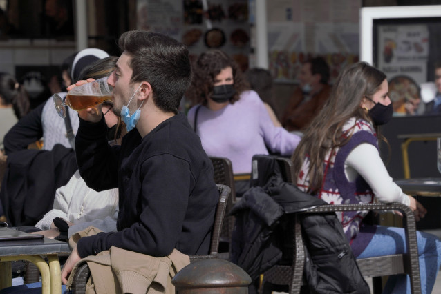Varias personas en la terraza de un restaurante durante el primer día de la apertura parcial de la hostelería en Santiago de Compostela, A Coruña, Galicia (España), a 26 de febrero de 2021. La Xunta de Galicia reabre desde hoy parcialmente la hostelería y