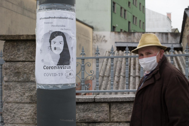 Un anciano pasa junto a una farola con un panfleto alusivo al Covid-19 en el municipio de Guitiriz, Galicia (España), a 26 de febrero de 2021.