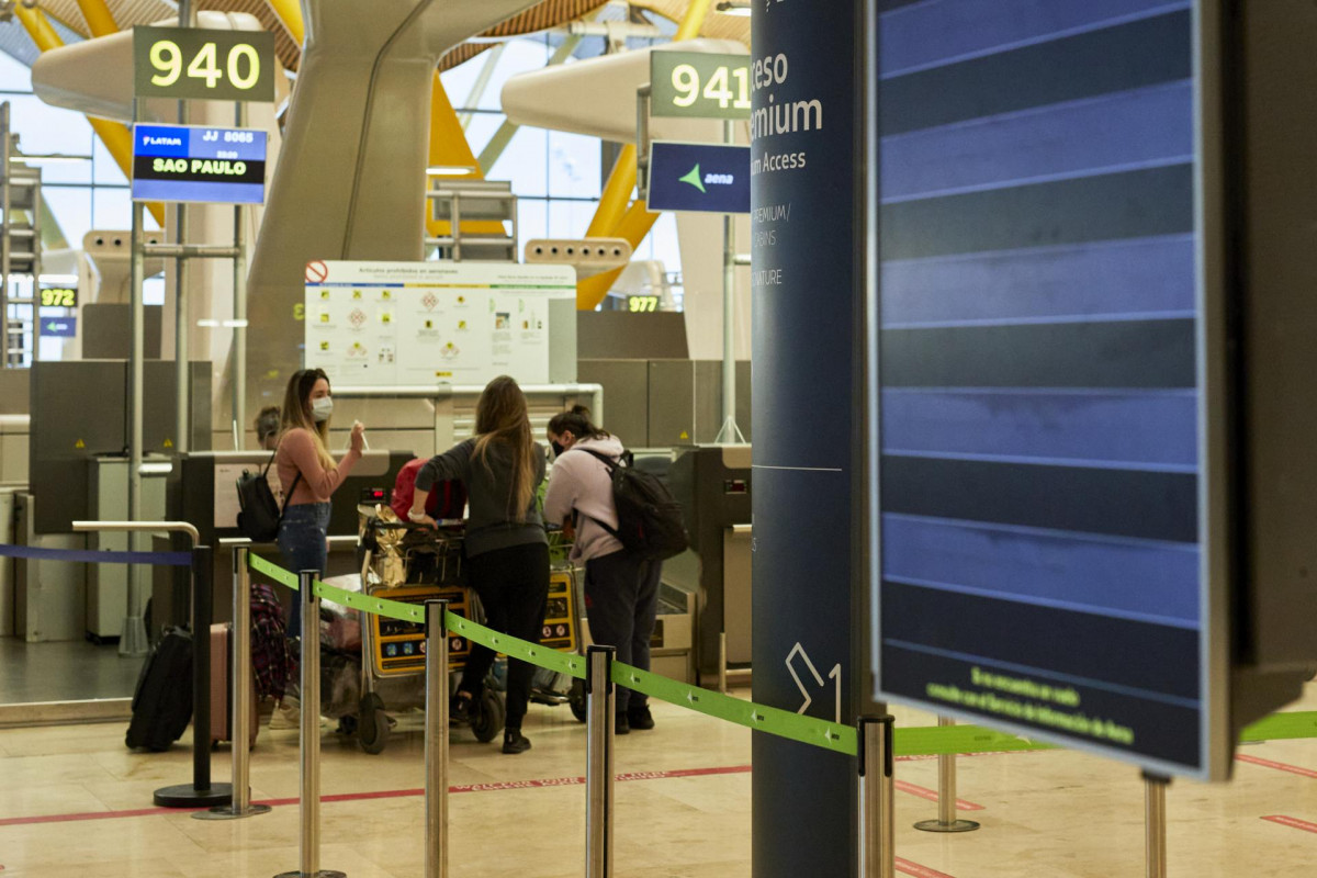 Varias personas facaturan su equipaje en la terminal T4 del Aeropuerto Adolfo Suárez Madrid-Barajas el mismo día en que se restringen los vuelos procedentes de Brasil y Sudáfrica, en Madrid, (España), a 3 de febrero de 2021. Esta restricción, impuesta por