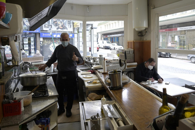 Un empleado trabaja en el interior de su establecimiento durante el primer día de la reapertura del interior de los bares y restaurantes en A Coruña a 8 de marzo de 2021
