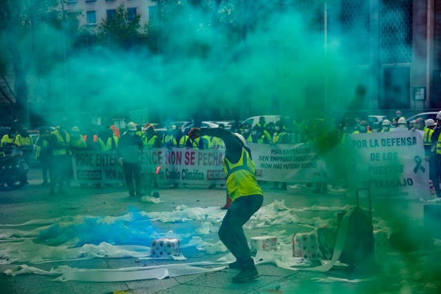 Trabajadores de la factoría pontevedresa de ENCE se concentran con chalecos amarillos, pancartas, tirando rollos de papel higiénico y rodeados de humo verde en las inmediaciones del Ministerio de Transición Ecológica en Madrid (España), a 12 de marzo de 2