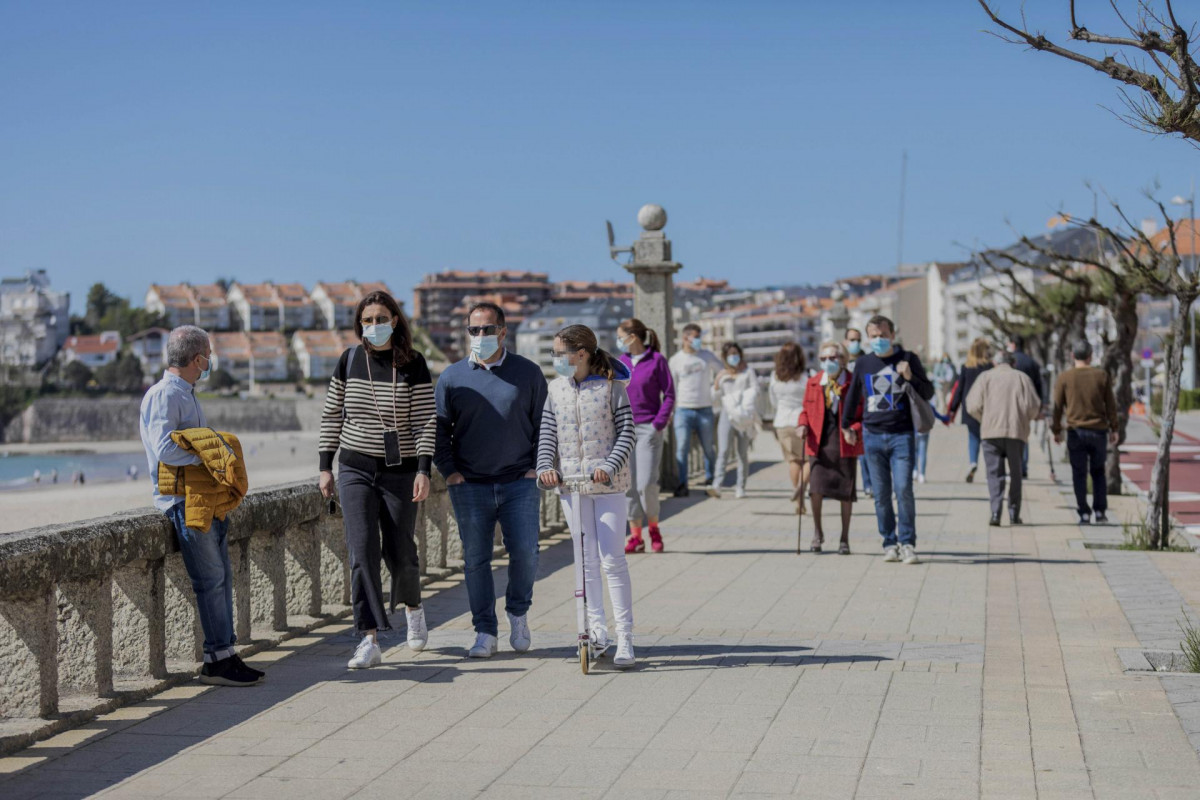 Varias personas caminan por un paseo marítimo en Sanxenxo, Pontevedra, Galicia (España), a 21 de marzo de 2021