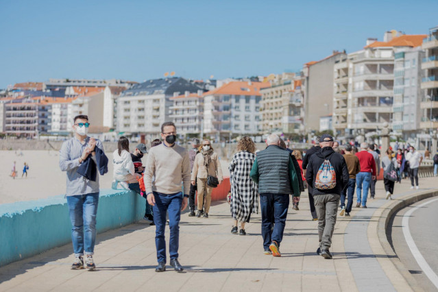 Varias personas pasean por el paseo marítimo de Sanxenxo, Pontevedra, Galicia (España), a 21 de marzo de 2021.