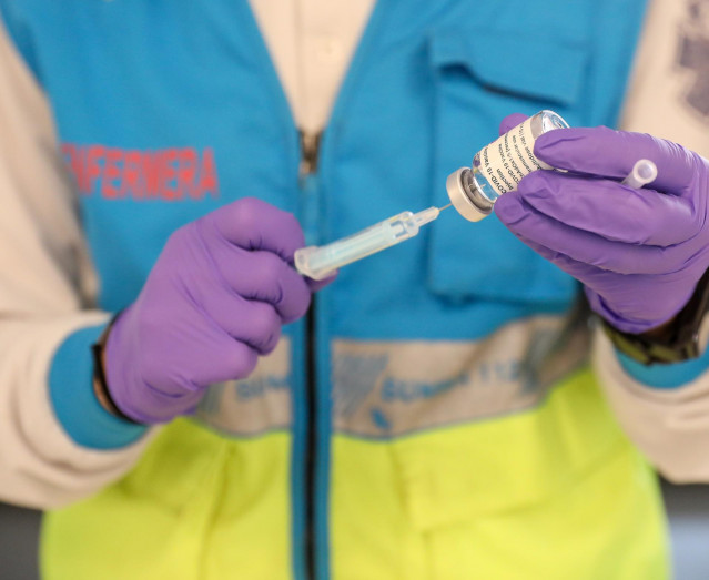 Un profesional sanitaria sostiene una jeringuilla y un vial con la vacuna del Covid-19, en un dispositivo instalado en el Estadio Wanda Metropolitano, en Madrid (España), a 30 de marzo de 2021. La Comunidad de Madrid ha comenzado a vacunar este martes fre