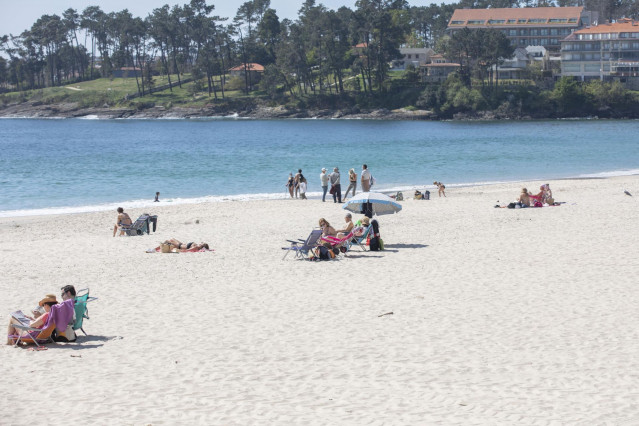 Varias personas en la playa de Sanxenxo, en Pontevedra, Galicia (España), a 27 de marzo de 2021. El subcomité clínico mantiene el nivel alto de restricciones en el concello de Sanxenxo, lo que conlleva que la hostelería solo puede servir en las terrazas y