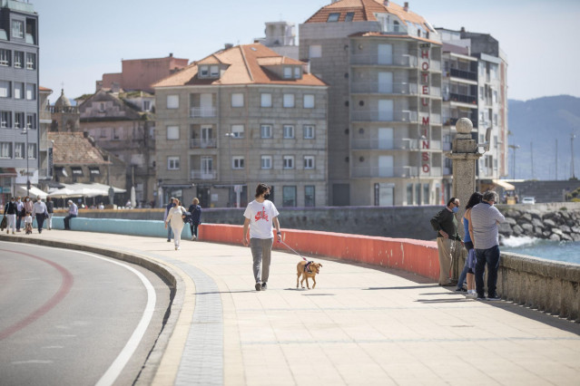Varias personas pasean por el Paseo Marítimo de Sanxenxo, en Pontevedra, Galicia (España), a 27 de marzo de 2021.