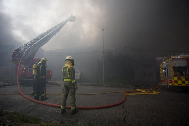 Bomberos trabajan en la extinción de un incendio en el Polígono Industrial Ceao, a 11 de abril de 2021, en Lugo, Galicia (España). El voraz incendio iniciado en la mañana de este domingo en el Polígono de O Ceao, en Lugo, ha quedado controlado pasado el m