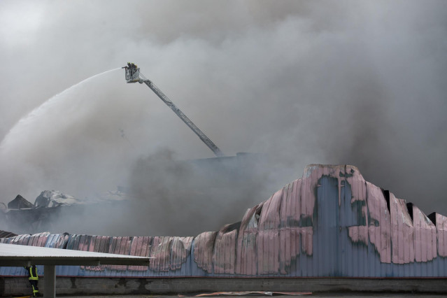 Bomberos trabajan en la extinción de un incendio en el Polígono Industrial Ceao, a 11 de abril de 2021, en Lugo, Galicia (España).