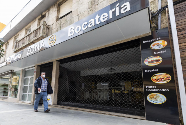 Un hombre camina frente a una cafetería cerrada en O Grove, el día en que entra en vigor el cierre perimetral del municipio, a 8 de abril de 2021, en Pontevedra, Galicia, (España).