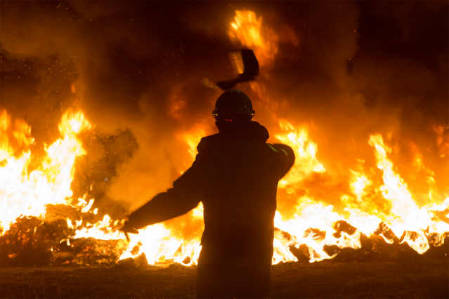Archivo - Un trabajador tira un elemento a una barricada durante un velatorio nocturno simbólico convocado por la fábrica de Alcoa, en  en San Cibrao, A Mariña, Lugo, Galicia (España), a 28 de noviembre de 2020.