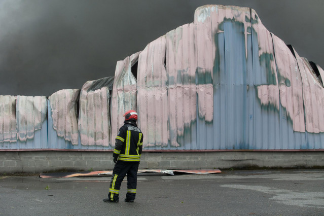 Bomberos trabajan en la extinción de un incendio en el Polígono Industrial Ceao, a 11 de abril de 2021, en Lugo, Galicia (España). El voraz incendio iniciado en la mañana de este domingo en el Polígono de O Ceao, en Lugo, ha quedado controlado pasado el m