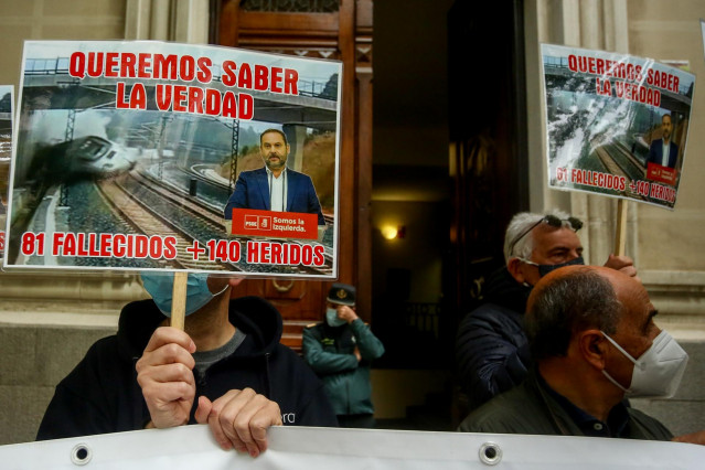 Varias víctimas del accidente ferroviario del Alvia se concentran con una pancarta y carteles en los que se lee: 