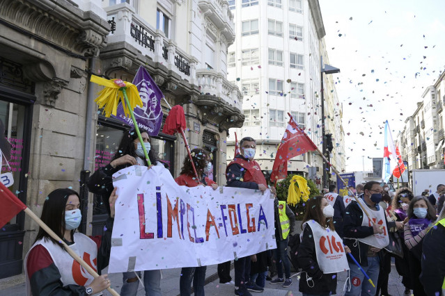 Varias personas con fregonas y una pancarta en una protesta convocada por CIG, CCOO y UGT para visibilizar la huelga del sector de la limpieza en la provincia de A Coruña