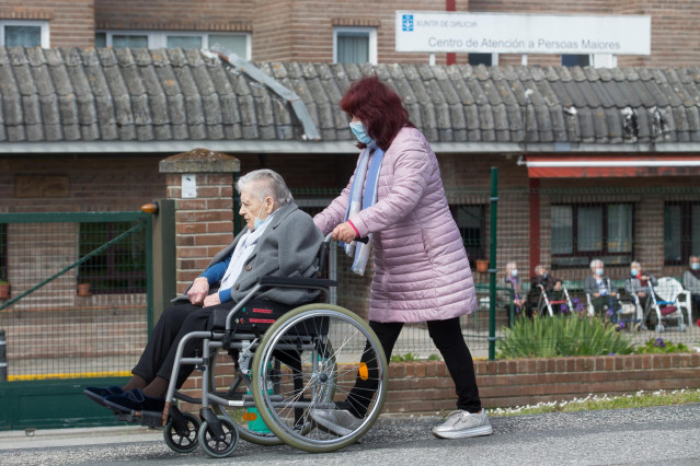 Una mujer pasea a una anciana en silla de ruedas, en las inmediaciones de la residencia geriátrica de As Gándaras para visitar a un familiar, a 17 de abril de 2021, en Lugo.