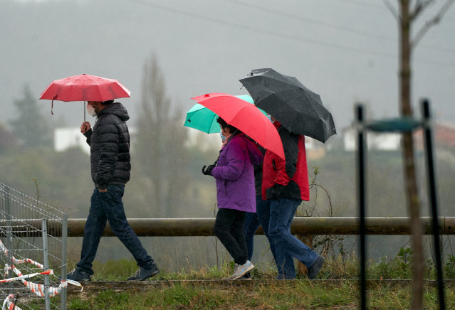Archivo - Varias personas se refugian con un paraguas de la lluvia en Vitoria, País Vasco (España), a 19 de marzo de 2021. Para la jornada de hoy, está activado el aviso amarillo por debajo de los 1.000 metros y habrá precipitaciones débiles moderadas. La