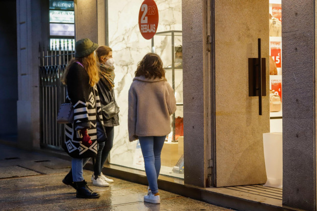 Archivo - Varias personas en el exterior de un comercio en una jornada marcada por el inicio de la entrada en vigor de una desescalada gradual en la región, en Vigo, Galicia (España).