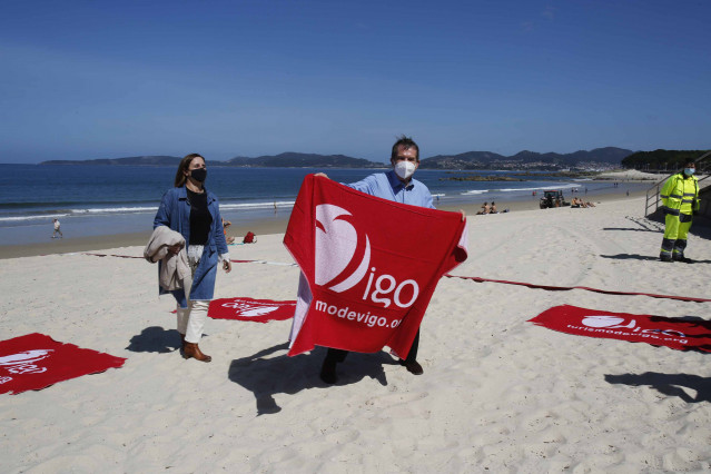 El alcalde de Vigo, Abel Caballero, coloca las cintas en la presentación del sistema de parcelación de playas con cintas separadoras en el arenal de Samil.