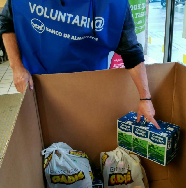 Una persona voluntaria del Banco de Alimentos de Vigo recoge alimentos donados.