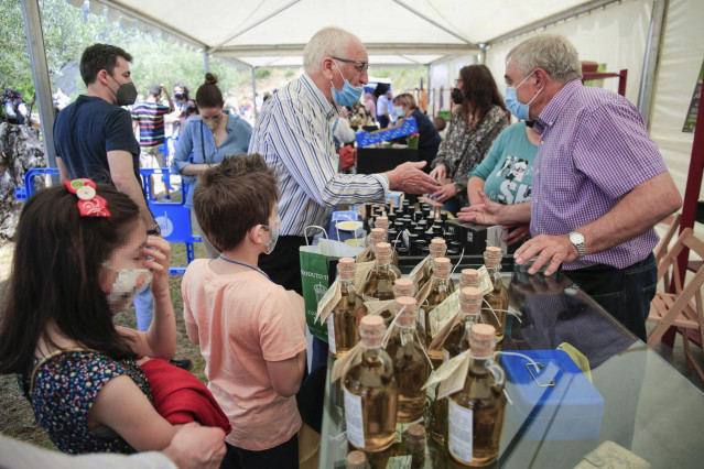 Varias personas visitan la XXI Muestra de Aceite de Quiroga, a 30 de mayo de 2021, en Bendilló, Quiroga, Lugo, Galicia (España).