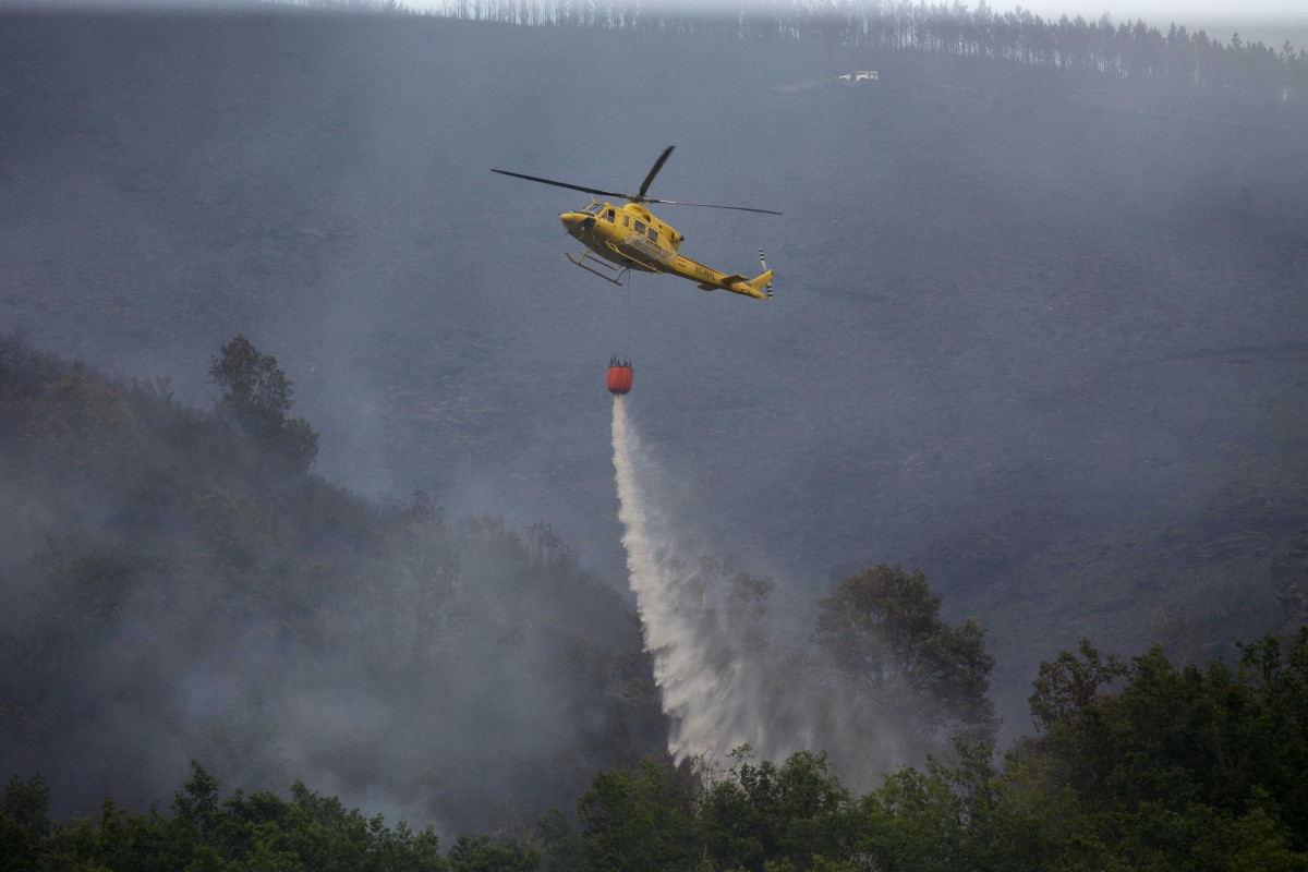 Labores de extinción del incendio forestal que se originó la pasada madrugada en el entorno de la localidad de Ferreirós de Abaixo, en el municipio de Folgoso do Courel, a 12 de junio de 2021, en L