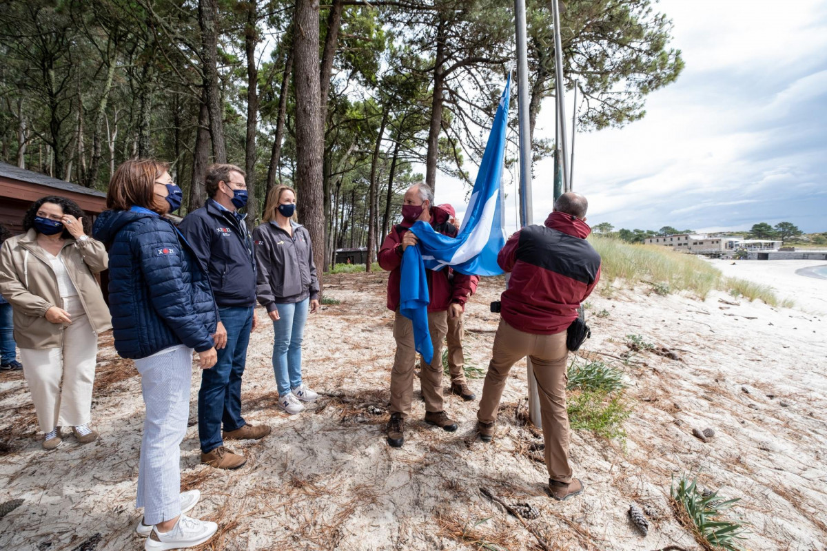 El presidente de la Xunta, Alberto Núñez Feijóo, y la conselleira Ángeles Vázquez, participan en el izado de la bandera azul en la playa de Rodas, en las islas Cíes.