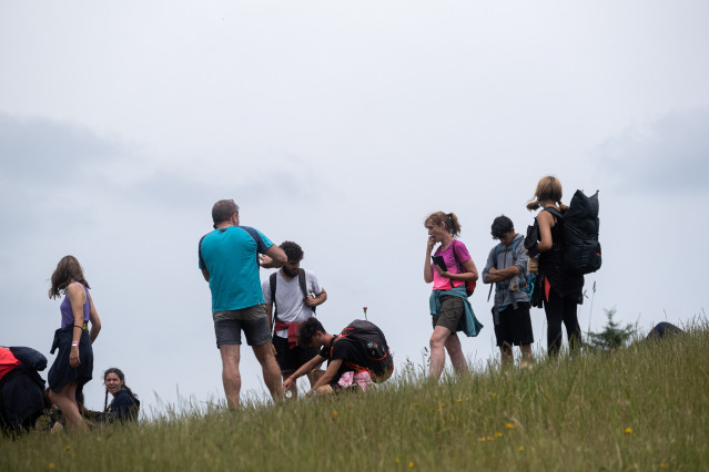 Varios peregrinos descansan sin mascarilla, en el Monte do Gozo, la última etapa del camino de Santiago, durante el primer día en el que no es obligado el uso de la mascarilla en exteriores desde el inicio de la pandemia, a 26 de junio de 2021, en Santiag