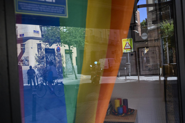 Bandera LGTBI en un escaparate del barrio de Chueca durante la celebración del Día Internacional del Orgullo LGTBI