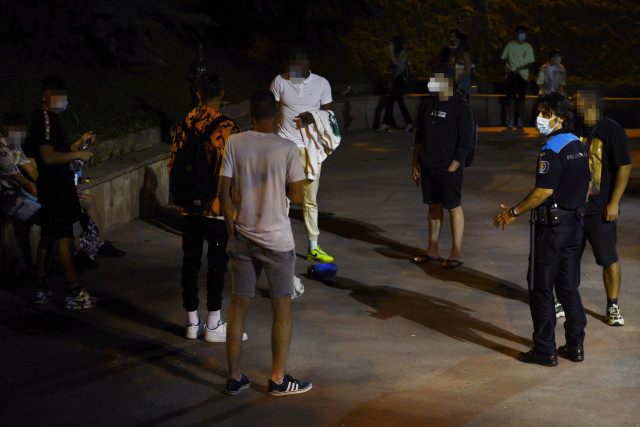 Un agente de la Policía Local informa a un grupo de jóvenes en el parque de las Zapatillas (barrio de San Francisco), de la posible sanción por hacer botellón, a 4 de julio de 2021, en Ourense, Galicia (España). Durante el fin de semana, las fuerzas y cue