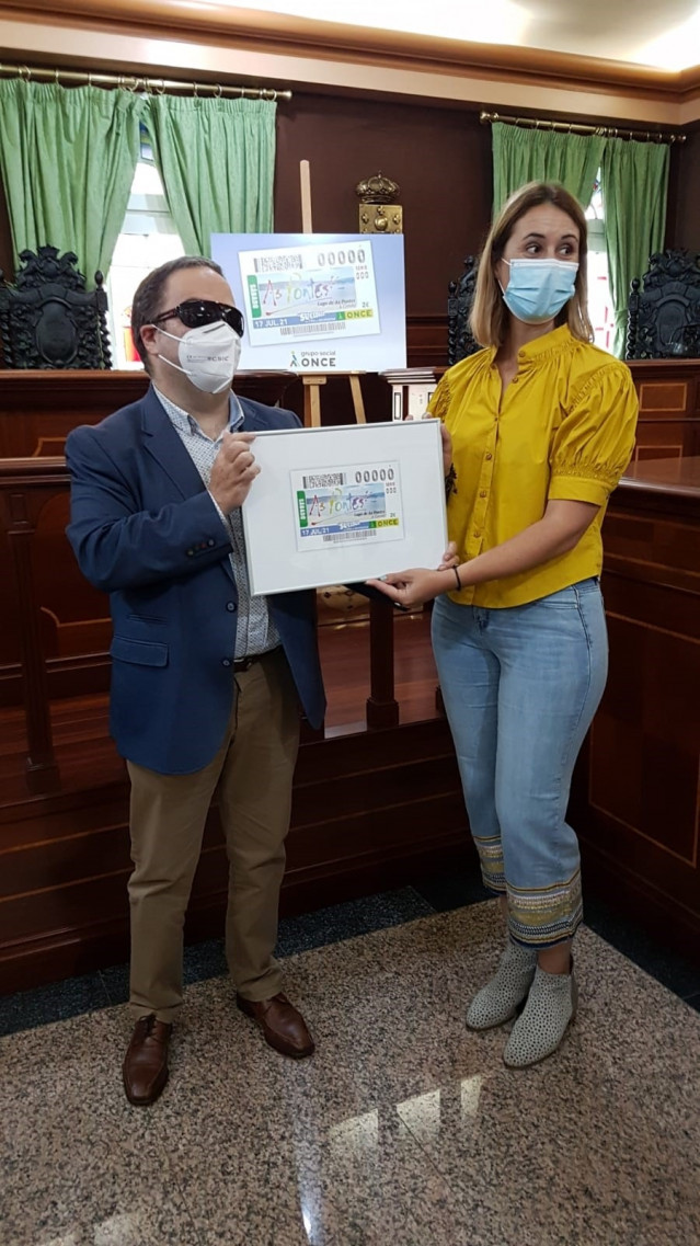 El presidente del Consejo Territorial de ONCE-Galicia, Carlos Fernández Lamigueiro, entrega a la concejala de Turismo y Consumo de As Pontes (A Coruña), Elena López Seco, una recreacion del boleto.