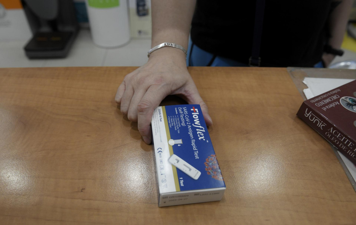 Un cliente enseña un test de antígenos de detección del COVID-19 en la farmacia situada en la Calle Tucán, 7, a 20 de julio de 2021, en Madrid (España). El Consejo de Ministros aprueba hoy la ven