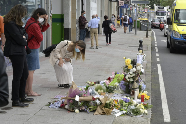 Una joven se acerca ante el altar colocado en la acera donde fue golpeado Samuel, el joven asesinado en A Coruña el pasado sábado 3 de julio, a 6 de julio de 2021, en A Coruña