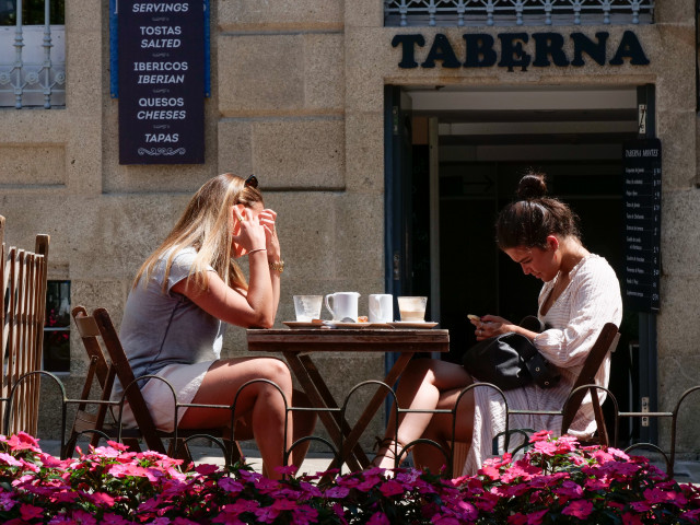 Dos mujeres en la terraza de un restaurante de la Rua da Raiña, el día en que el TSXG declara nula la petición de certificado Covid para entrar en hostelería, a 12 de agosto de 2021, en Santiago de Compostela, A Coruña, Galicia (España).