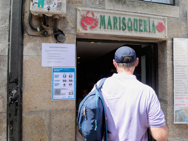 Varias indicaciones de obligatoriedad de presentar certificados antes de acceder al interior, en una marisquería de la Rua do Franco de Santiago de Compostela