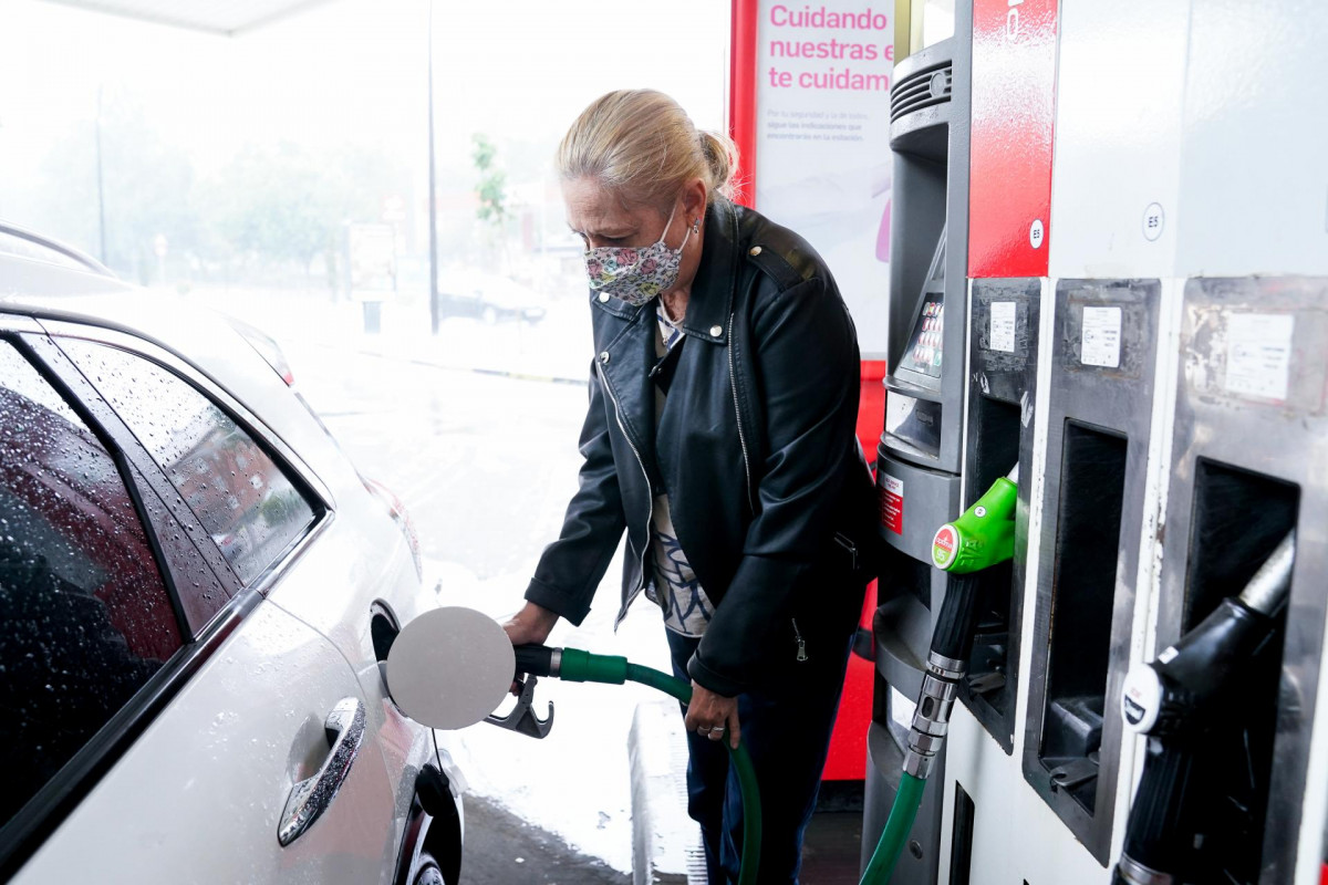 Archivo - Una mujer pone gasolina a su vehículo en una gasolinera.
