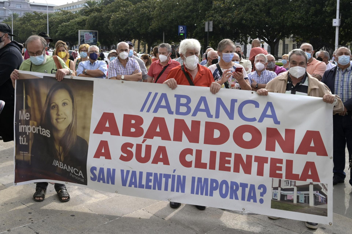 Un grupo de personas sostienen una pancarta durante la manifestación contra el cierre de oficinas de la entidad Abanca ante la sede de Abanca en A Coruña, a 2 de septiembre de 2021, en A Coruña, Ga