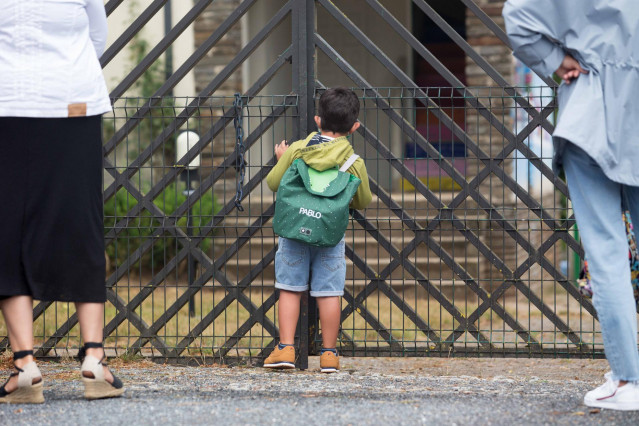 Un niño se asoma a las puertas del CEIP Manuel Mallo de Nadela, durante el primer día del curso escolar 2021-2022 en Educación Infantil y Primaria