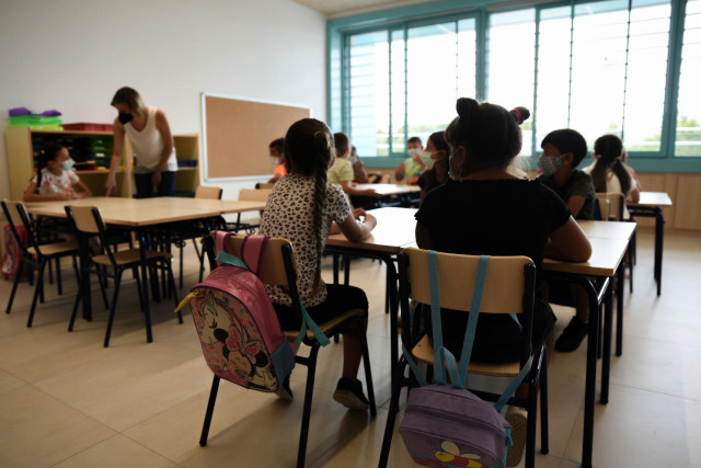 Una profesora junto con alumnos de Educación Primaria en una  de las aulas del colegio Les Arts, de reciente construcción, durante el primer día del curso escolar 2021-2022 en la Comunidad Valenciana, a 8 de septiembre de 2021, en Valencia, Comunidad Vale
